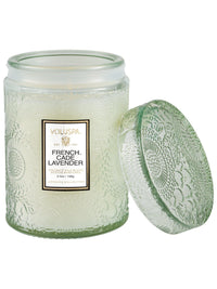 Voluspa French Cade Lavender Small Jar Candle, 5.5 oz, pale green embossed jar with the lid beside it