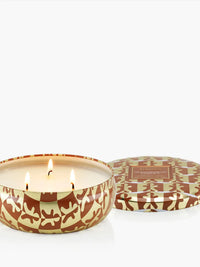 Voluspa Gingerbread Chalet 3-Wick Tin Candle, three lit wicks in a brown and cream tin with the lid beside it