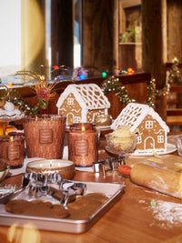 Voluspa Gingerbread Chalet candles displayed with gingerbread houses and holiday baking